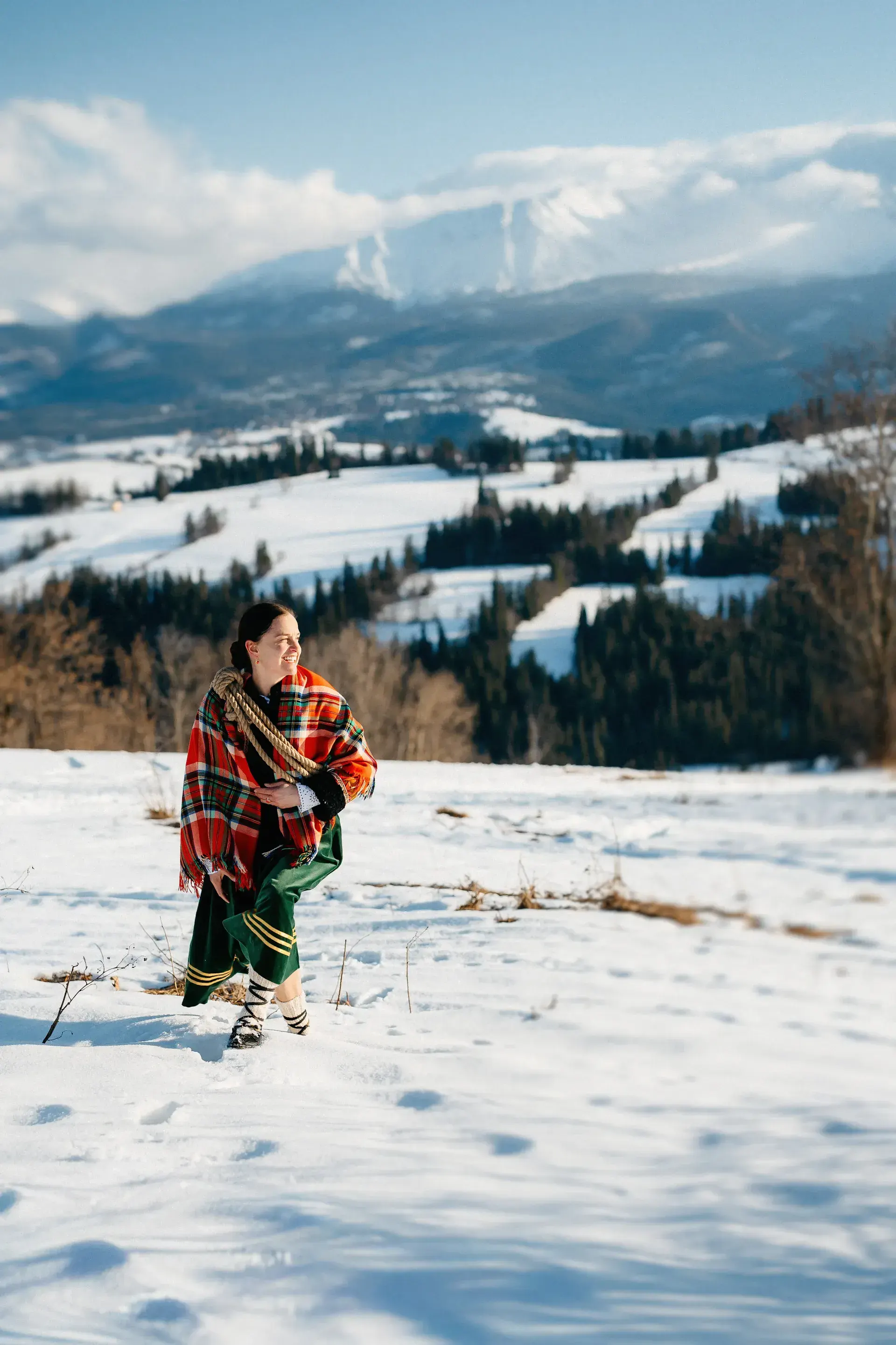 Kobieta w góralskim szalu na śniegu z widokiem na Tatry
